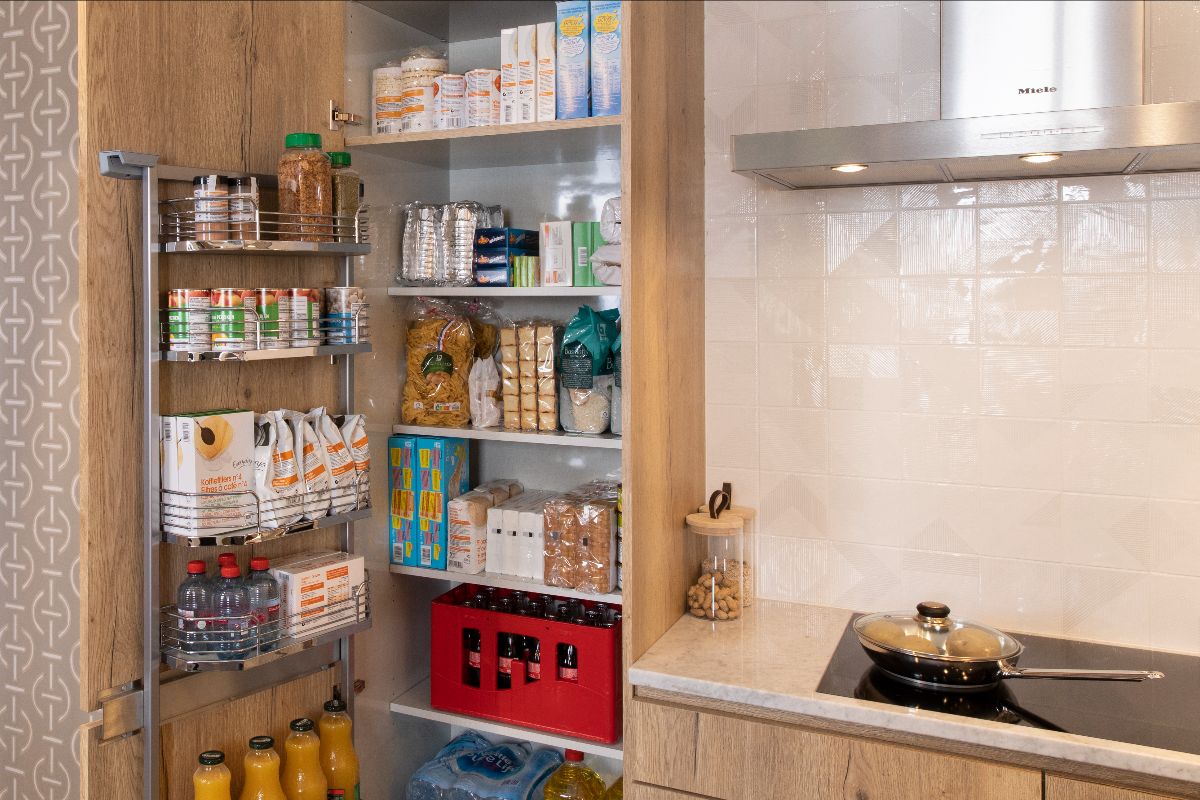 Colonne de rangement de cuisine ouverte, avec hotte et plaque de cuisson visibles à droite