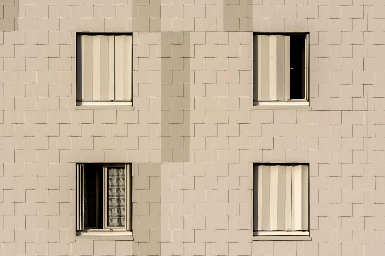 Façade revêtue d’ardoises de fibrociment posées sur ossature ventilée, autour de fenêtres
