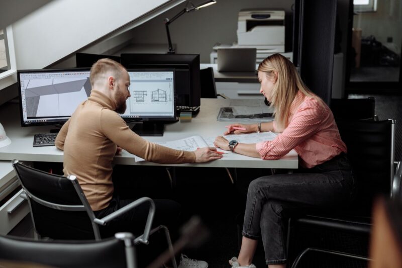 Client et architecte discutant un projet autour de plans, bonne communication