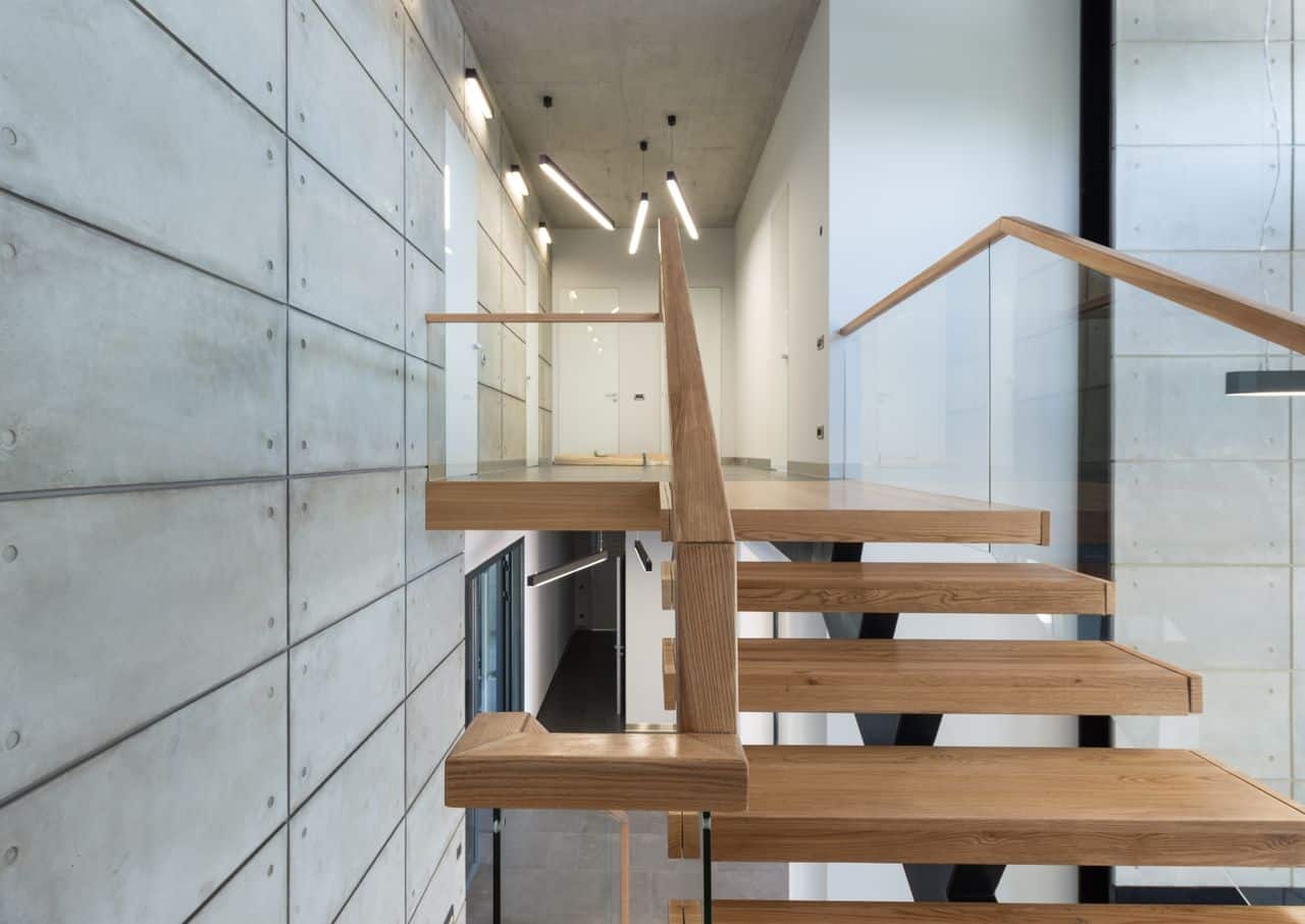 Escalier droit en bois aux marches régulières, garde-corps vitré, dans un intérieur contemporain