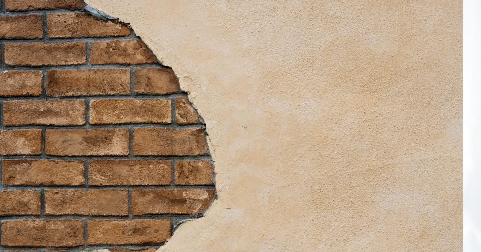 Enduit tombé sur une portion de mur laissant les briques apparentes : mettre la maçonnerie à nu est ce qui permet à un mur inondé de sécher