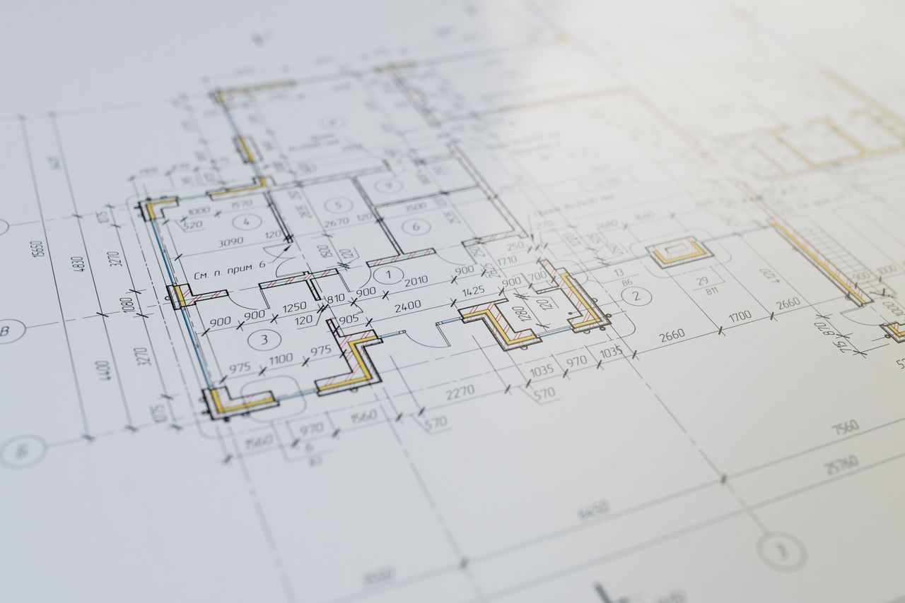 %titre de l'article% Plans d’architecte d’un projet de construction posés sur une table