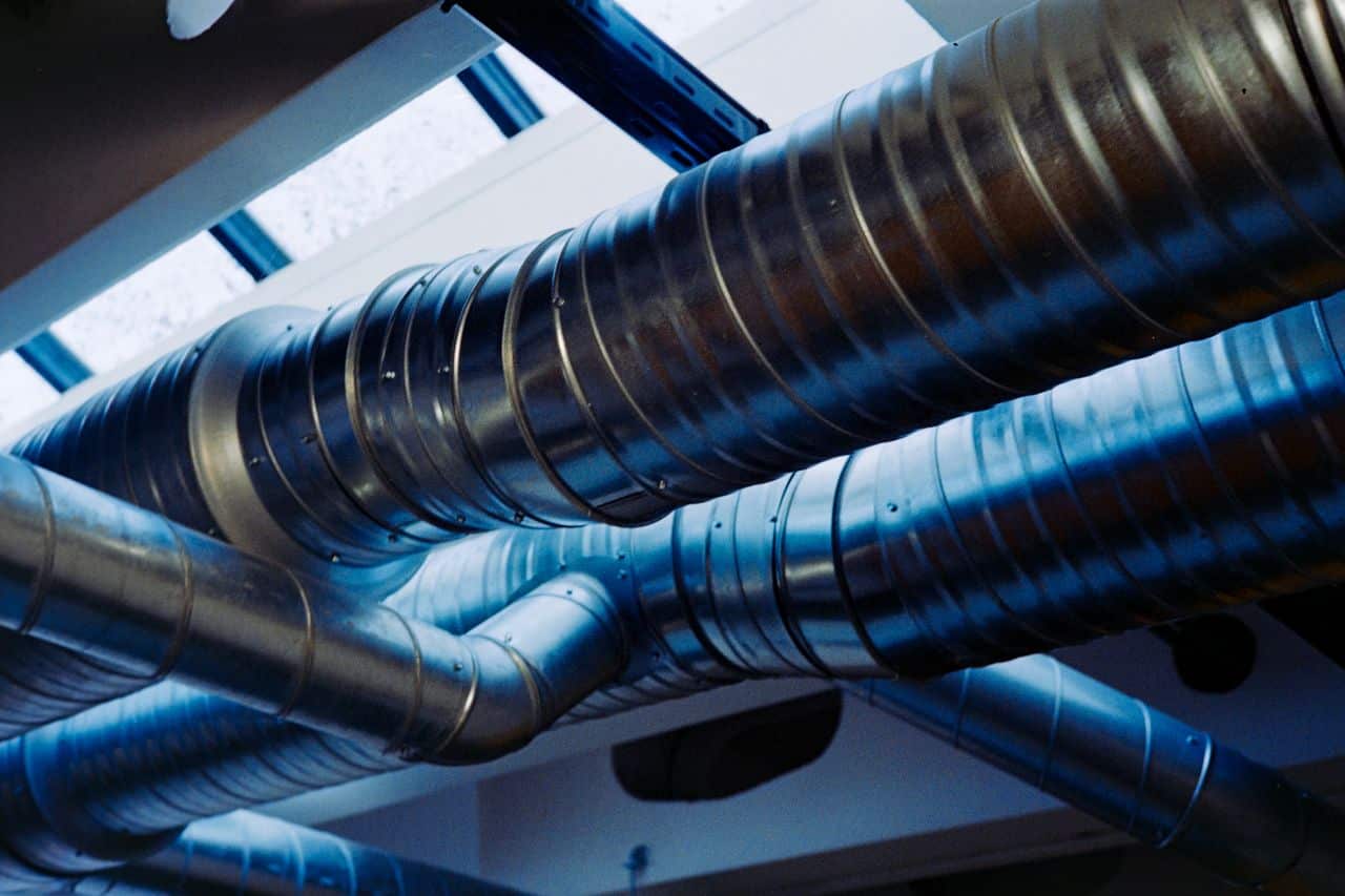 Réseau de gaines de ventilation apparent sous plafond avant fermeture, au moment de la réception du chantier