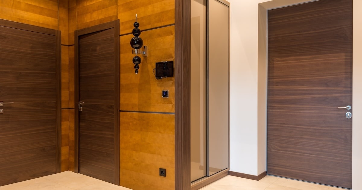Hall d’entrée desservi par plusieurs portes en bois : rien ne distingue visuellement une porte résistant au feu de ses voisines